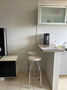 a kitchen with a counter and a stool in it at Flat completo no centro. in Palmas