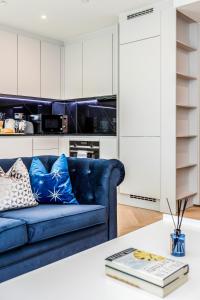 ein Wohnzimmer mit einem blauen Sofa und einem Tisch in der Unterkunft New Riverside Apt sleeps 5 Easy to tour London in London
