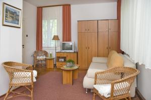 a living room with a couch and chairs and a tv at Dom Wypoczynkowy Helunia in Jurata