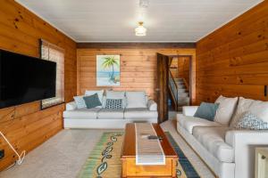 ein Wohnzimmer mit einem Sofa und einem Flachbild-TV in der Unterkunft Kawaha on the Lake in Rotorua