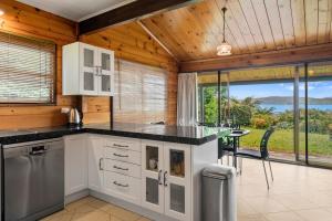 eine Küche mit einem Tisch und Meerblick in der Unterkunft Kawaha on the Lake in Rotorua