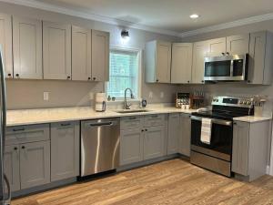 une cuisine avec des armoires blanches et des appareils en acier inoxydable dans l'établissement Cozy Lake Home at Raysville, à Thomson