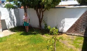 Eine Frau steht im Gras neben einem Baum in der Unterkunft El Esparragal Santa Clara del Mar in Santa Clara del Mar + 8 Fotos