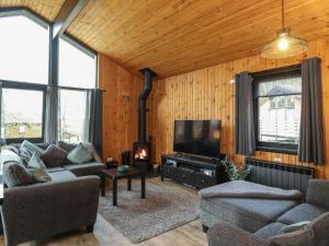 a living room with a couch and a flat screen tv at Newsham Lodge in Penrith