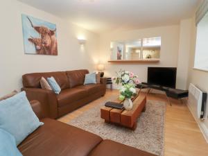 a living room with a couch and a tv at The Wheat House in Stratford-upon-Avon