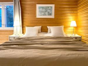 a bedroom with a large bed with wooden walls at Houses by The Sea in Salpar