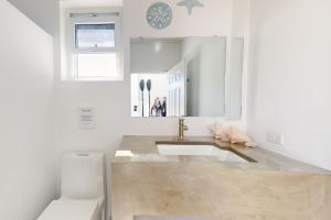 bagno bianco con lavandino e servizi igienici di White Sands Beach House a Maya Beach