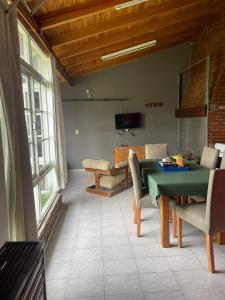 a living room with a green table and chairs at Casa con pileta "TU CASITA EN VIEDMA" calle Junin 1877 in Viedma