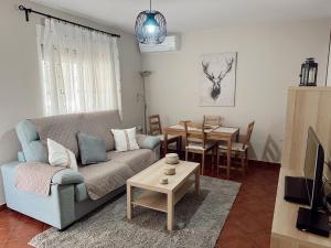 sala de estar con sofá y mesa en Apartamentos Maria, en Málaga