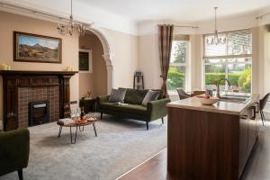 a living room with a kitchen and a fireplace at Plas Meirion Apartment 3 in Trefriw