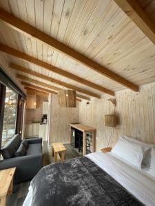 a bedroom with a bed and a couch and a table at Cabañas Los Huemules in Malalcahuello