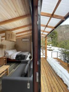 a room with a bed on a wooden deck at Cabañas Los Huemules in Malalcahuello