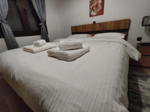 a white bed with towels on top of it at Emily Apartment 5 in Chrysoupolis