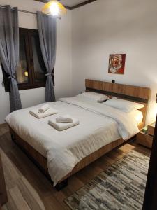 a bedroom with a large bed with two towels on it at Emily Apartment 5 in Chrysoupolis