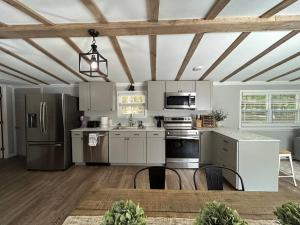 a kitchen with stainless steel appliances and a wooden ceiling at Relaxing Cabin Near Raysville in Thomson