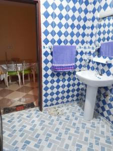 La salle de bains est pourvue d'un lavabo et de carrelage bleu et blanc. dans l'établissement راحة المسافر، Rahat al moussafir, à Azilal