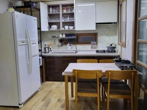 a kitchen with a white refrigerator and a table with chairs at Donghae sea hill House in Yŏngdŏk