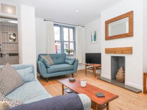 a living room with a blue couch and a fireplace at The Cottage on The Square in Newton Abbot