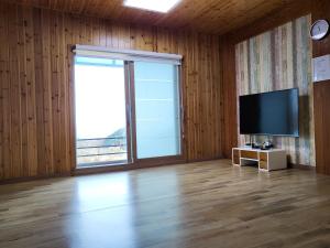 a living room with a large window and a flat screen tv at Donghae sea hill House in Yŏngdŏk
