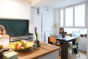 a kitchen with a table with a bowl of fruit on it at Spacious duplex - near park in Paris