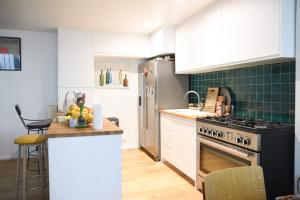 a kitchen with white cabinets and a stove top oven at Spacious duplex - near park in Paris