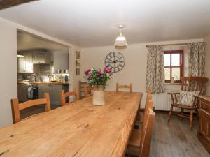 a dining room with a wooden table with flowers on it at Cherry Tree Barn in Ulverston