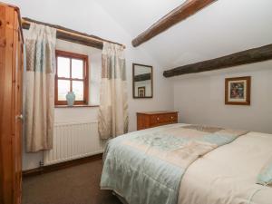 a bedroom with a bed and a window at Cherry Tree Barn in Ulverston