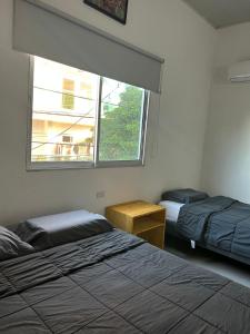 - une chambre avec 2 lits et une fenêtre dans l'établissement ALTAVITA, à Puerto Colombia