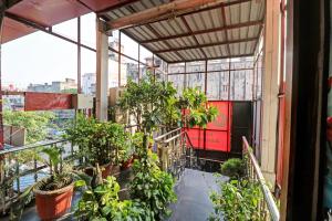a balcony with plants and a red train at OYO Flagship Hotel park view 1 in Meerut