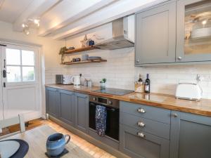 a kitchen with gray cabinets and a counter top at Spring Cottage in Norwich
