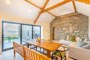 sala de estar con mesa de madera y sofá en Ysgubor Maen Y Bardd en Conwy