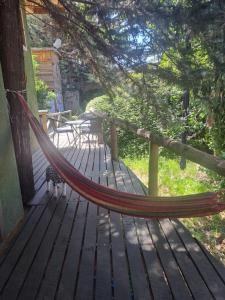 a hammock on the porch of a house at Ruca lemu lodge in San Antonio