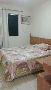 een slaapkamer met een bed met een bloemendeken erop bij Ap Serra Park in Rio Quente