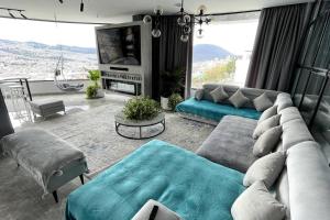 a living room with a couch and a tv at Lujoso penthouse con vista panoramica in Quito