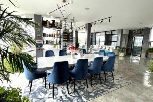 a dining room with a table and blue chairs at Lujoso penthouse con vista panoramica in Quito