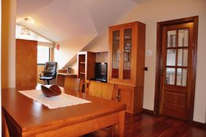 a dining room with a table and a chair at Alojamiento Santa Maria III in Milladoiro