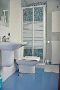 a white bathroom with a toilet and a sink at Alojamiento Santa Maria III in Milladoiro