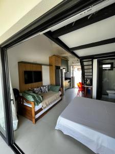um quarto com uma cama grande e uma cozinha em Lar aconchegante Praia do Forte na Praia do Forte