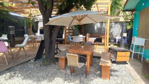 une terrasse avec un parasol, des tables et des chaises dans l'établissement Espacio Mycelium, à Coyhaique
