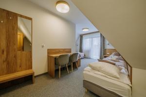 a bedroom with a bed and a desk and a mirror at Ośrodek Wypoczynkowy Molanda in Biały Dunajec +31 photos
