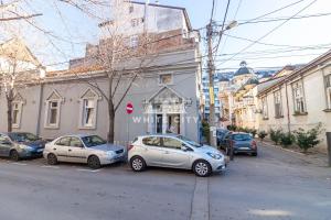 un gruppo di auto parcheggiate di fronte a un edificio di Townhouse - WHITE CITY Apartments a Belgrado