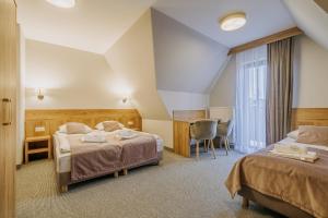 ein Hotelzimmer mit 2 Betten und einem Schreibtisch in der Unterkunft Ośrodek Wypoczynkowy Molanda in Biały Dunajec