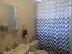 a bathroom with a sink and a toilet and a shower curtain at acogedora casa nueva in Cerrillo Caiván +6 photos