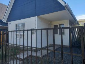 a fence in front of a house with a gate at acogedora casa nueva in Cerrillo Caiván
