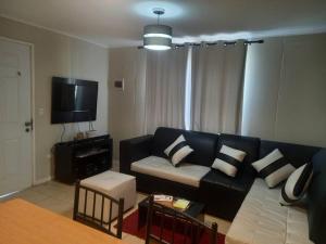 a living room with a black couch and a tv at acogedora casa nueva in Cerrillo Caiván