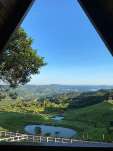 uma vista para um rio a partir de uma janela em Rancho Sol Poente - Rancho Queimado - SC em Rancho Queimado