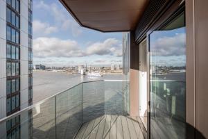 einen Balkon in einem Gebäude mit Blick auf das Wasser in der Unterkunft New Riverside Apt sleeps 5 Easy to tour London in London