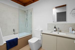 a bathroom with a shower and a toilet and a sink at Just Beachy in Blairgowrie