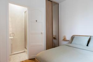 - une chambre blanche avec un lit et un placard dans l'établissement Nouveau T2 à 7 min de Saint-Lazare, à Asnières-sur-Seine