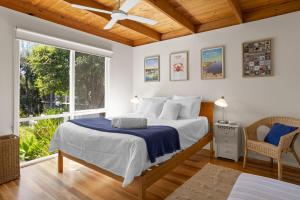 a bedroom with a bed with a ceiling fan at Just Beachy in Blairgowrie